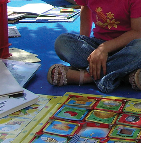 Un enfant assis en tailleur devant un livre jeux